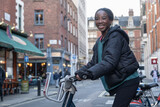 Fototapeta Londyn - Young woman renting city bike