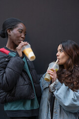 Wall Mural - Portrait of two cheerful women drinking bubble tea 