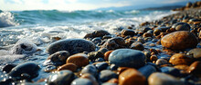 Wet Pebbles Glisten On The Shore As Waves Break Gently In The Golden Light Of Sunrise