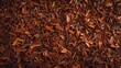 Closeup of textured background made from dried red rooibos tea leaves.