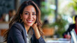 © Mattie - Professional hispanic 35, 40, woman looking at the camera and  smiling with long hair and modern clothing and  earrings, with  a soft focus background, happy in a work meeting, room for copy