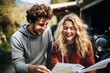 © Néstor - Couple laughing while planning a trip with a map