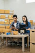 © NINENII - Couple start up small business owner at workplace. small business entrepreneur SME or freelance asian woman working with box at home.
