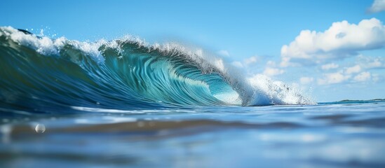 Wall Mural - A massive ocean wave breaks under a sunny sky, creating a magnificent sight with fluid water, wind, and a beautiful horizon.