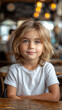 © sofiko14 - Caucasian boy in white t-shirt and jeans sitting at table at modern cafe.