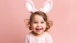 Kleines junges Mädchen mit Hasenohren auf pinken pastelligen Hintergrund