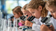© Serega - Children look through microscopes in a bright scientific laboratory