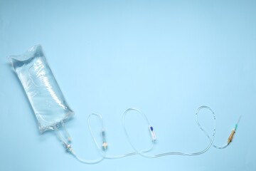 Wall Mural - IV infusion set on light blue background, top view. Space for text