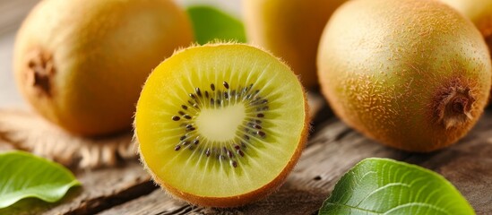 Wall Mural - A close-up of a halved kiwi, a Hardy kiwi fruit, on a wooden table showcasing its natural beauty as a staple food.