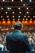 © Emanuel - A business and entrepreneurship conference. A speaker delivering a talk at a business meeting. Audience in the conference hall. Rear view of an unrecognized attendee