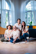 © StockImageFactory - Portrait of happy Indian family of four sitting in modern living room