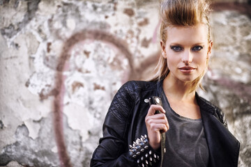 Poster - Woman, portrait and confident in edgy fashion with punk rock hairstyle, biker and cool in funky clothes by graffiti wall. Young model, face and leather jacket in urban town with trendy by street art