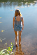 © boomeart - Back view of young woman entering the river
