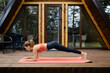 © boomeart - Woman does plank exercise on the porch of a-frame cabin