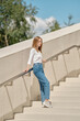 © boomeart - Woman standing with her back against railing on stairs