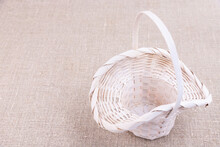 White Wicker Basket Stands On A Linen Tablecloth