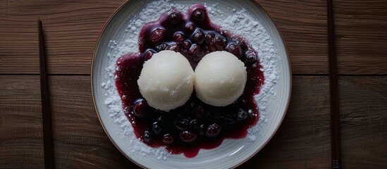 Wall Mural - A dish composed of a white plate with two scoops of ice cream and a handful of blueberries.