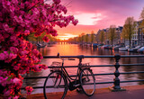 Fototapeta Zachód słońca - Beautiful sunrise over Amsterdam, The Netherlands, with flowers and bicycles on the bridge in the spring