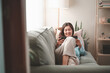 © sornthanashatr - woman, happy, home, lifestyle, sofa, tablet, online, sitting, communication, young. beautiful woman relaxing on comfortable sofa with tablet, playing social or chatting online via social networks