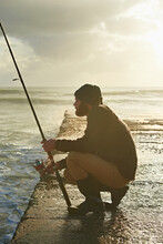 Man, Waiting And Fishing On Beach In Nature, Relax And Natural Sea Hobby For Wellness On Vacation. Fisherman, Travel Or Holiday In Cape Town By Ocean, Adventure Or Patient By Hook For Fish To Bite