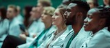 Fototapeta  - Diverse group of medical professionals attending a seminar. intently focused audience in white lab coats. ideal for educational content use. AI