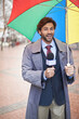 © Alexandra/peopleimages.com - Weather, man and reporting on rain, umbrella and journalism with media and anchor. Presenter, meteorology and person with microphone and professional in New York city with info and breaking news