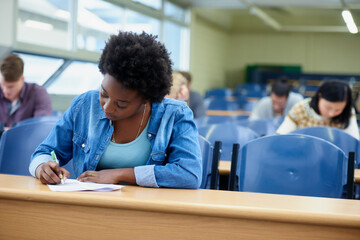 Poster - Writing, college and black woman student in classroom studying for test, exam or assignment. Education, university and African female person working on project with knowledge in lecture hall.