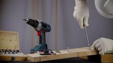 Carpenter Screwing Bolt Into Wood . Repairman Installs Furniture DIY	