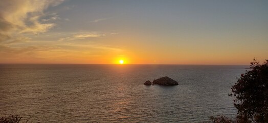 Canvas Print - the sun sets over the ocean, as seen from a cliff