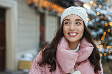 Canvas Print - Portrait of smiling woman on city street in winter. Space for text