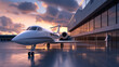 A private jet parked at a terminal during sunset