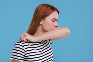 Poster - Woman coughing on light blue background. Cold symptoms