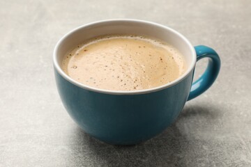 Wall Mural - Cup of aromatic coffee on light grey table, closeup