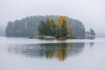 Poster - Small island located in the middle of a tranquil lake, surrounded by lush greenery.