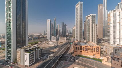 Wall Mural - Aerial view of Dubai Downtown skyline with many towers timelapse. Busy traffic on the intersection with overpass. Moving shadows in Business area. Skyscraper and high-rise buildings from above, UAE.