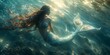 © Marin Zhu - A mermaid swimming underwater with a magnificent tail illuminated by light rays. Concept: magic and mystery of the ocean depths, mythical creatures of the depths