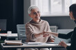 © gstockstudio - Two confident women shaking hands and smiling while sitting at the office desk together