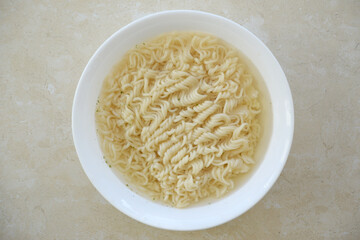 Wall Mural - Bowl of instant cooking noodles on white marble table. Traditional asian food