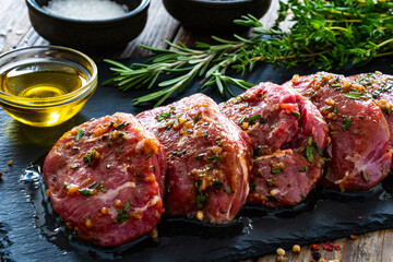 Sticker - Raw pickled pork cheeks on stony cutting board on wooden table
