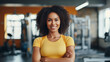 © Carolina Santos  - Muscular black woman in sportswear, fitness trainer smiling and looking at the camera in the background of the gym.