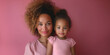 © anatoliycherkas - Portrait of african american mother and her little daughter together on Mother's Day on pink background at home