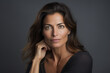 © vejaa - Portrait of beautiful middle aged woman with long dark hairs wearing black dress posing on gray background