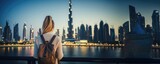 Fototapeta Nowy Jork - Dubai Twilight: A Happy Tourist Woman, Back View, Admires the Stunning View of the Burj Khalifa and the Illuminated Dubai Skyline at Twilight, Embracing the Futuristic Urban Beauty.

