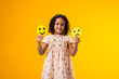Smiling kid girl holding sad and happy emoticons in hands. Mental health, psychology and children's emotions concept
