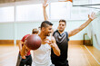 © Marko Geber - Young men playing basketball in a indoor gym
