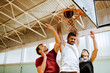 © Marko Geber - Young men playing basketball in a indoor gym