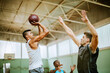 © Marko Geber - Young people playing basketball in an indoor basketball gym