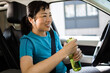 © Davor - Active woman drinking water in car after workout
