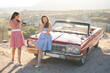 © Tsyb Oleh - two beautiful girl in a retro dress are photographed on camera  on  mountain landscape in Cappadocia near a red retro car