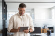 © Stock 4 You - Happy Latin Hispanic bearded stylish mature adult professional business man, smiling Indian senior businessman CEO holding digital tablet using fintech tab application standing inside company office.